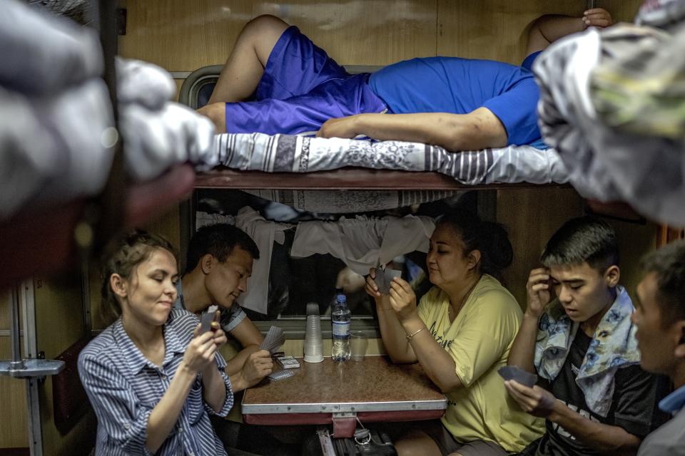 People play cards on the way to Aralsk, Kazakhstan, Friday, June 30, 2023. (AP Photo/Ebrahim Noroozi)