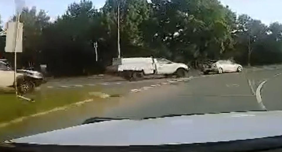 Dashcam footage showing white ute and silver Mazda at roundabout. 