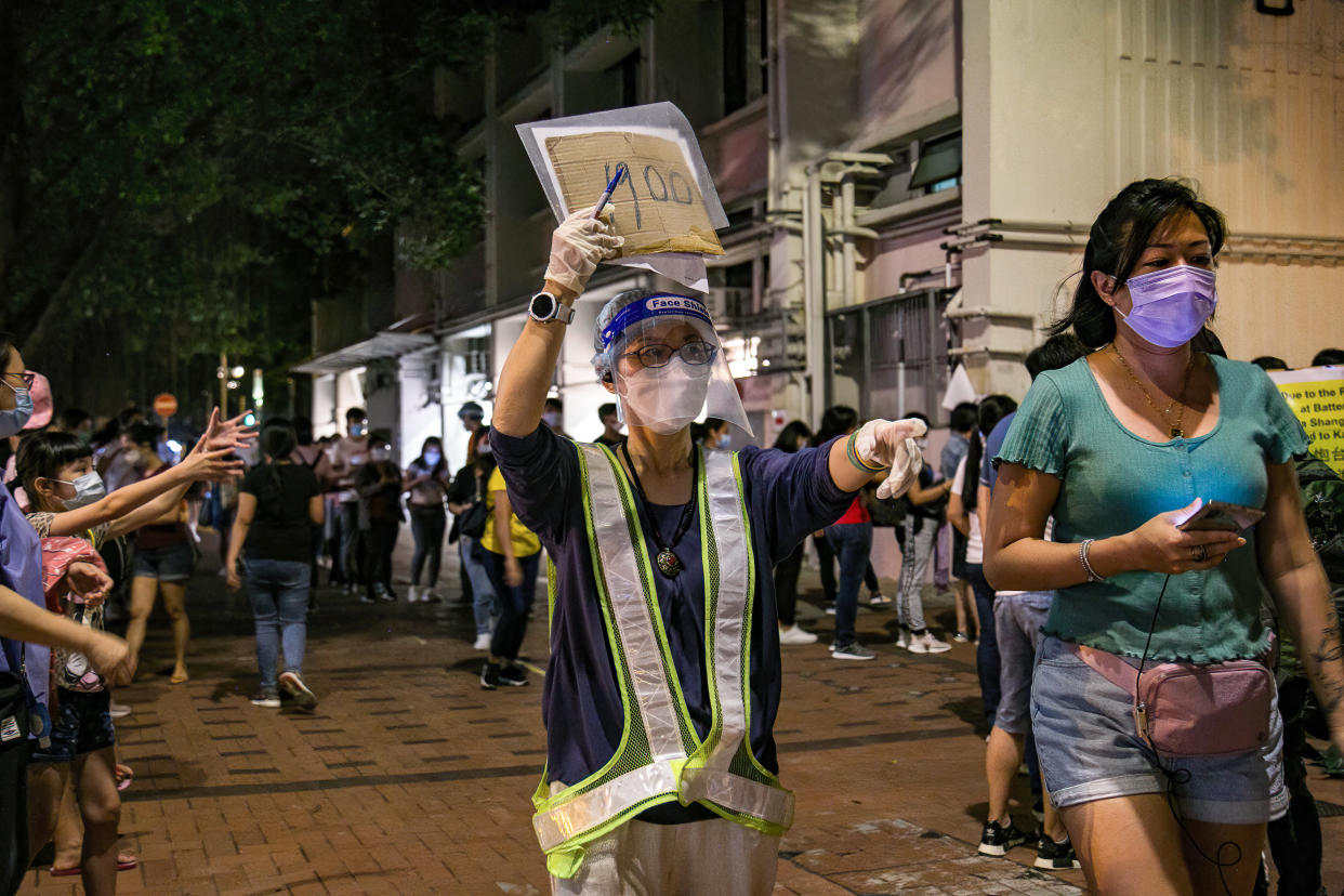 HONG KONG, CHINA - 2021/05/01: A health worker wearing a face shield trying to guide the COVID-19 -test queue outside the community testing centre in Yau Ma Tei.
After two helpers were confirmed to have a more infectious Covid-19 strain, the government ordered the foreign domestic helpers to take a test by May 9 along with attempt to make vaccination a requirement for visa renewals. Huge crowds were seen queuing outside community testing centre in Yau Ma Tei, as many used their Labour Day holiday to take the mandatory test. (Photo by Dominic Chiu/SOPA Images/LightRocket via Getty Images)