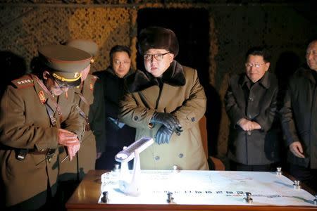 North Korean leader Kim Jong Un talks with officials at the ballistic rocket launch drill of the Strategic Force of the Korean People's Army (KPA) at an unknown location, in this undated photo released by North Korea's Korean Central News Agency (KCNA) in Pyongyang on March 11, 2016. REUTERS/KCNA