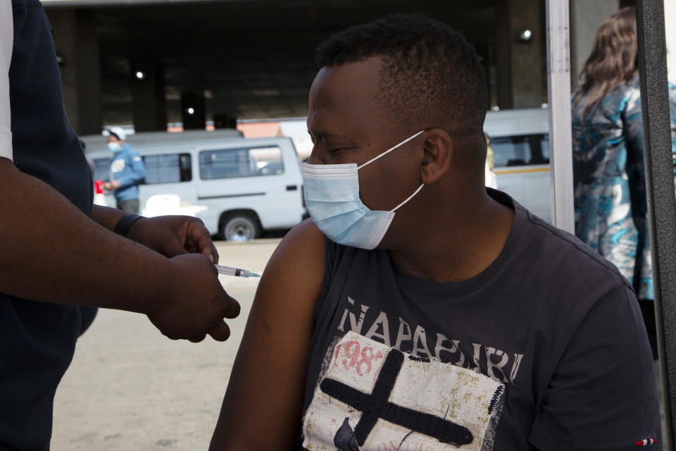A man receives a Johnson & Johnson vaccines at a pop-up vaccination centre, at the Bare taxi rank in Soweto, South Africa, Friday, Aug. 20, 2021. Faced with slowing numbers of people getting COVID-19 jabs, South Africa has opened eligibility to all adults to step up the volume of inoculations as it battles a surge in the disease driven by the delta variant. (AP Photo/Denis Farrell)