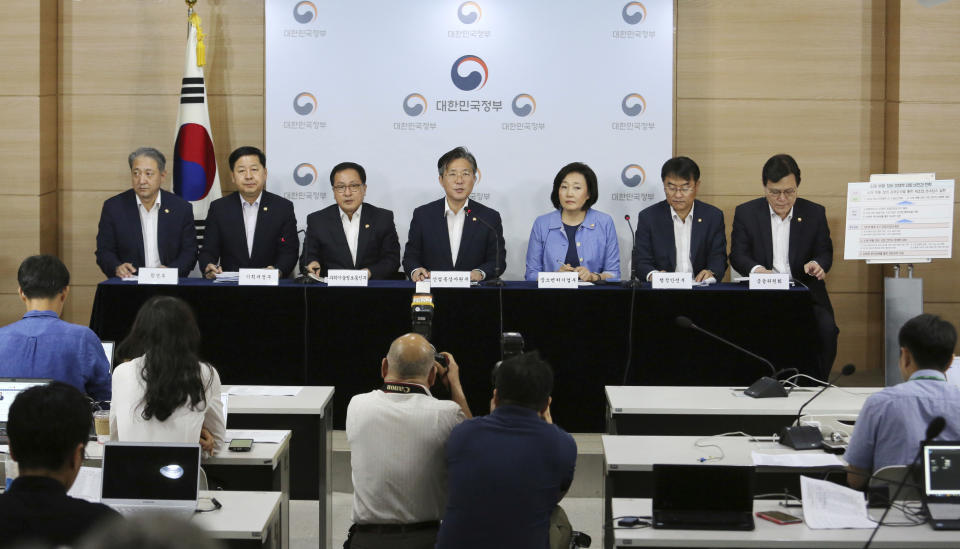 Sung Yun-mo, center, South Korea's minister of Trade, Industry and Energy, speaks during a press conference at the government complex in Seoul, South Korea, Monday, Aug. 5, 2019. Sung said South Korea will spend 7.8 trillion won ($6.5 billion) over the next seven years to develop technologies for industrial materials and parts as it moves to reduce its dependence on Japan during an escalating trade row. The announcement came days after Japan's Cabinet approved the removal of South Korea from a list of countries with preferential trade status. (AP Photo/Ahn Young-joon)