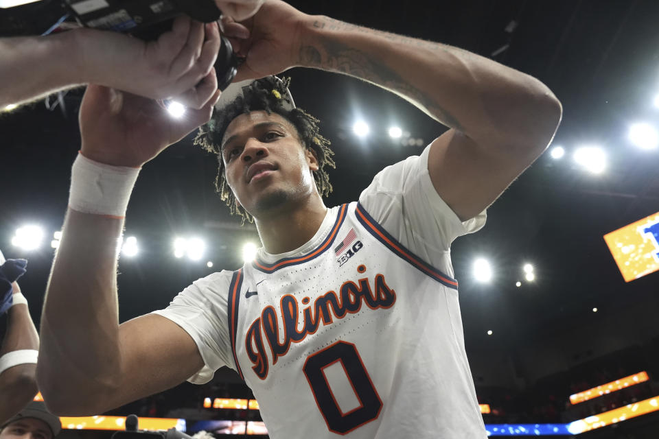 Illinois guard Terrence Shannon Jr. autographs a camera after the team's win against Wisconsin in an NCAA college basketball game in the championship of the Big Ten Conference tournament, Sunday, March 17, 2024, in Minneapolis. (AP Photo/Abbie Parr)