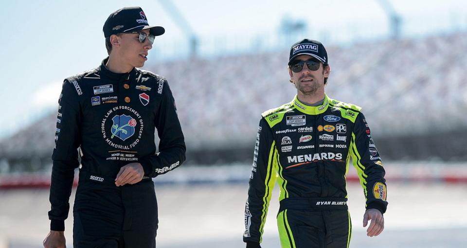 Carson Hocevar and Ryan Blaney walk together on pit road.