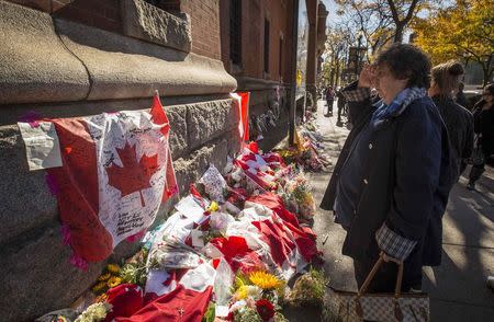 A woman salutes at a makeshift memorial in honour of Cpl. Nathan Cirillo outside of The Lieutenant-Colonel John Weir Foote Armoury in Hamilton, October 23, 2014. REUTERS/Mark Blinch