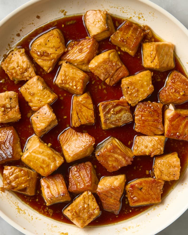 overhead shot of cubed salmon cooking in its glaze in a pan.