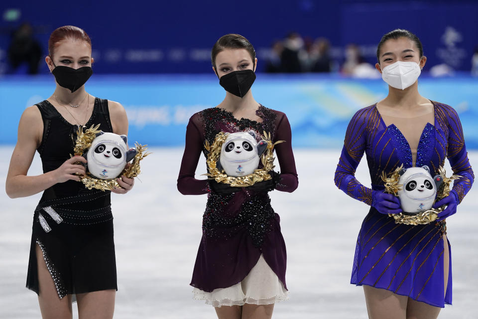 Gold medalist Anna Shcherbakova, centre, of the Russian Olympic Committee, stands with silver medalist and compatriot Alexandra Trusova, left, and bronze medalist Kaori Sakamoto, of Japan, following the women's free skate program during the figure skating competition at the 2022 Winter Olympics, Thursday, Feb. 17, 2022, in Beijing. (AP Photo/David J. Phillip)