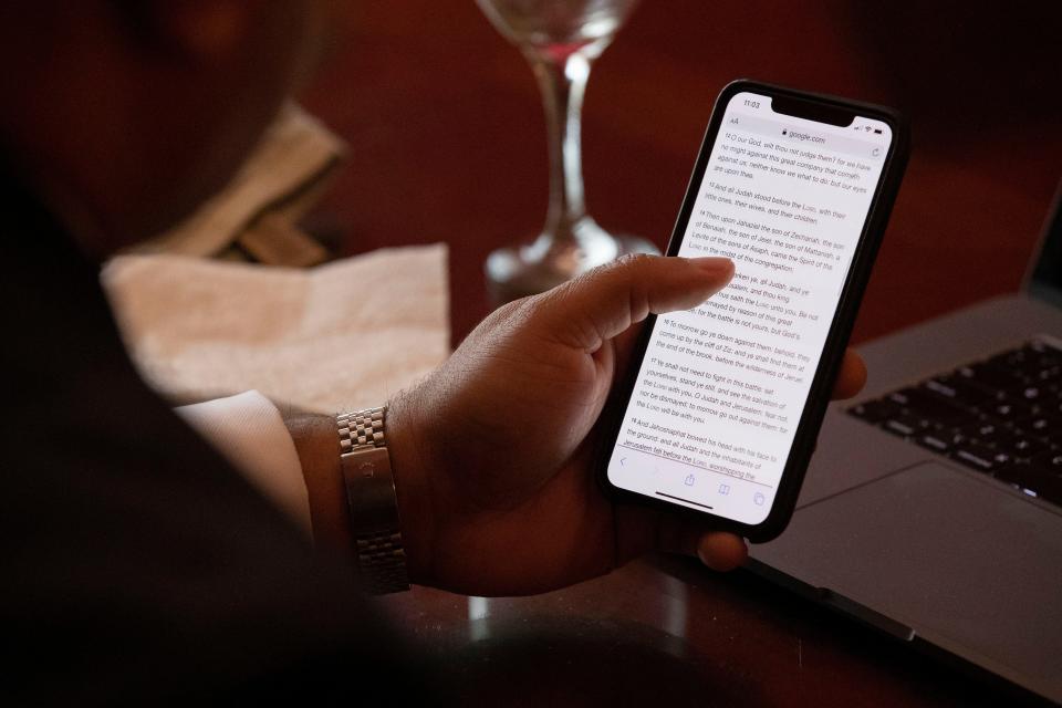 A man in Memphis, Tennessee, reads a Bible verse on his cellphone in 2020 while livestreaming a church service. In Fayetteville in 2023, the fastest cellphone service for reading Bible verses online, watching livestreams of church services, or doing any other online activity, is T-Mobile.