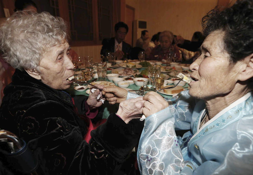 South Korean Lee Young-shil, 87, left, and her North Korean daughter Dong Myung-sook, 66, give food to each other in a dinner during the Separated Family Reunion Meeting at Diamond Mountain resort in North Korea, Thursday, Feb. 20, 2014. (AP Photo/Yonhap, Lee Ji-eun)