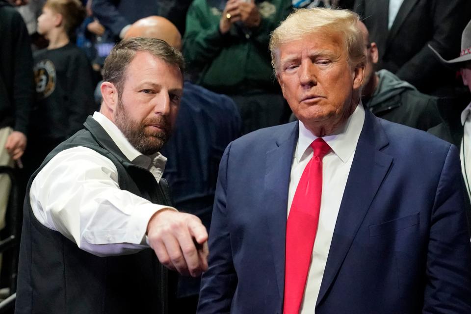 United States Sen. Markwayne Mullin, left, gestures to former President Donald J. Trump, right, as they talk before the NCAA Wrestling Championships, Saturday, March 18, 2023, in Tulsa, Okla. (AP Photo/Sue Ogrocki)