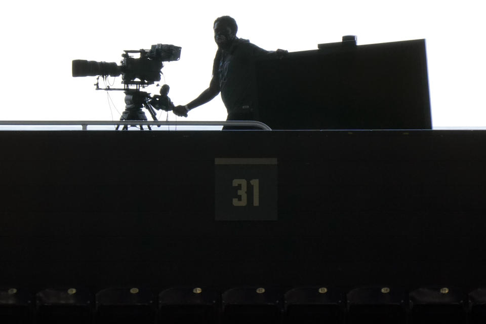 FILE - A television cameraman moves a camera before the start of a baseball game between the Miami Marlins and the Atlanta Braves, Aug. 14, 2020, in Miami. Major League Baseball added three executives to its new local media department as it prepares for a possible takeover of local broadcasts for 17 teams amid the financial deterioration of the Bally and AT&T SportsNet regional sports networks, the commissioner's office said Wednesday, March 1, 2023. (AP Photo/Wilfredo Lee, File)