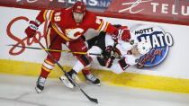 Ottawa Senators' Tim Stutzle, right, is checked by Calgary Flames' Nikita Nesterov during second-period NHL hockey game action in Calgary, Alberta, Sunday, March 7, 2021. (Jeff McIntosh/The Canadian Press via AP)