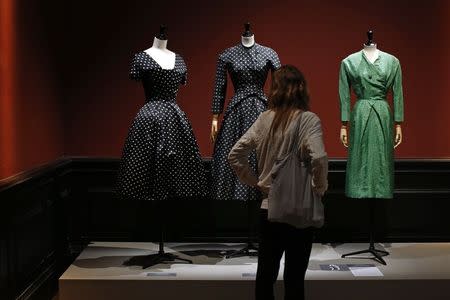 A visitor looks at vintage dresses by designers Christian Dior, Jacques Heim and Givenchy presented in the exhibition "Les Annees 50, La mode en France" (The 50s. Fashion in France, 1947-1957) at the Palais Galliera fashion museum in Paris, July 10, 2014. REUTERS/Benoit Tessier