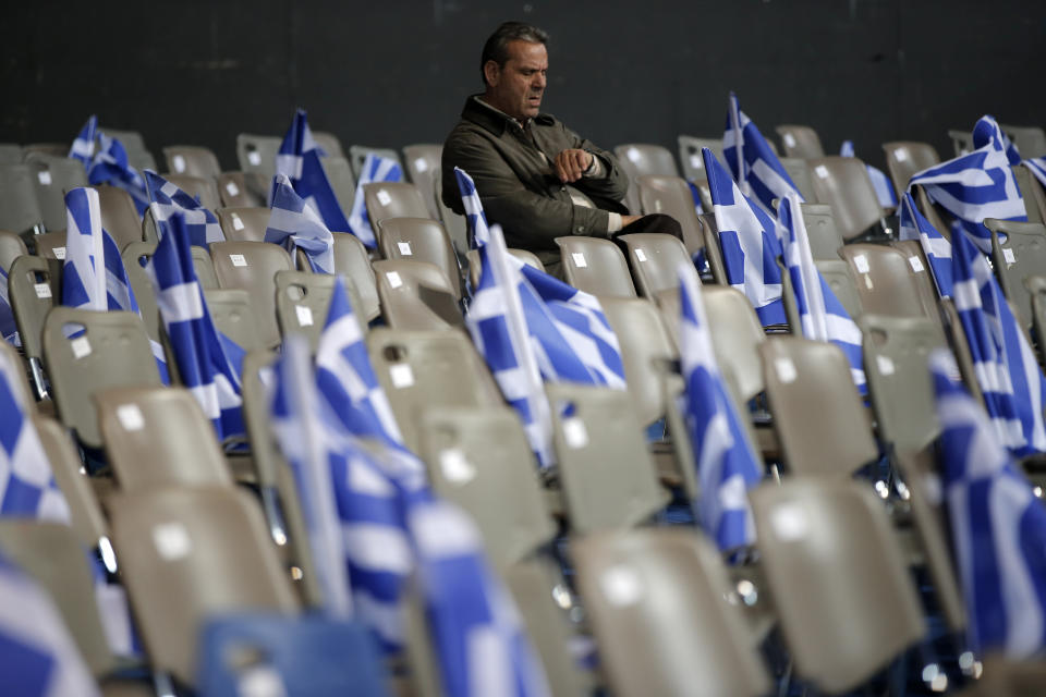 A supporter of New Democracy party, who denied to be identified, looks at his watch ahead of Prime Minister's Antonis Samaras pre-election speech at the Taekwondo Indoor Stadium in southern Athens on Friday, Jan. 23, 2015.  (AP Photo/Lefteris Pitarakis)