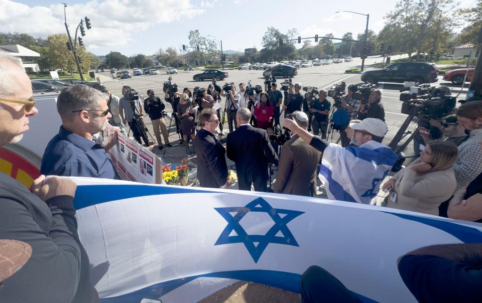 With the flag of Israel behind him, Jonathan Oswaks speaks Tuesday, Nov. 7, 2023, about Paul Kessler, 69, of Thousand Oaks, who died after an incident that happened at simultaneous demonstrations in support of Israel and Palestine at the intersection of Thousand Oaks and Westlake boulevards Sunday.