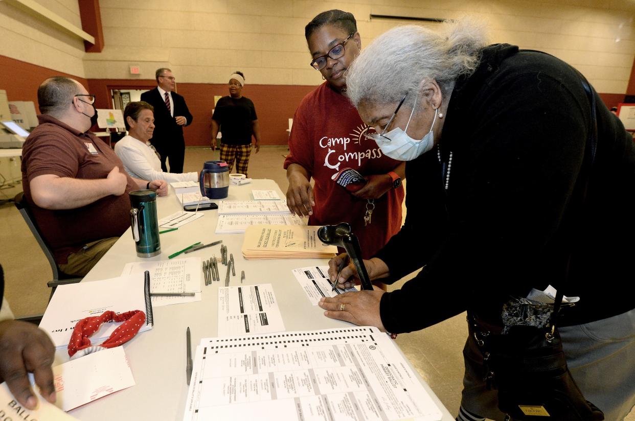 Sue Johnson, front right, and her daughter Claudia Johnson, back right, sign for their ballots before voting Tuesday at Union Baptist Church.