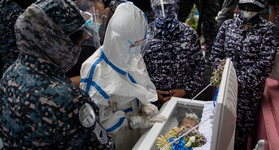 Detained Filipino activist Reina Mae Nasino, in a hazmat suit for protection against the coronavirus, mourns over her three-month-old daughter&#39;s coffin, who died while she was in jail, in Manila North Cemetery, Philippines, October 16, 2020. (Photo: REUTERS/Eloisa Lopez)