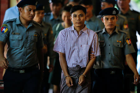 Detained Reuters journalist Kyaw Soe Oo is escorted by police while leaving after a court hearing in Yangon, Myanmar May 21, 2018. REUTERS/Ann Wang