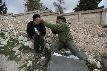 A Turkish-backed Free Syrian Army fighter tends to a man in Kafr Jana village north of Afrin, March 7. REUTERS/Khalil Ashawi