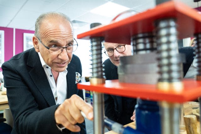 Entrepreneur Theo Paphitis points at a structure at the Hampshire School of Jewellery