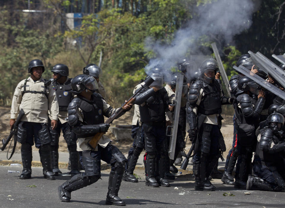 A member of the Bolivarian National Police fires tear gas at protesters in Caracas, Venezuela, Thursday, March 20, 2014. Thursday dawned with two more opposition politicians, San Cristobal Mayor Daniel Ceballos and San Diego Mayor Enzo Scarano, behind bars. Police used tear gas and water cannons to disperse a student-called protest of several thousand people in Caracas, some of those demonstrating against the arrests of the mayors. (AP Photo/Esteban Felix)