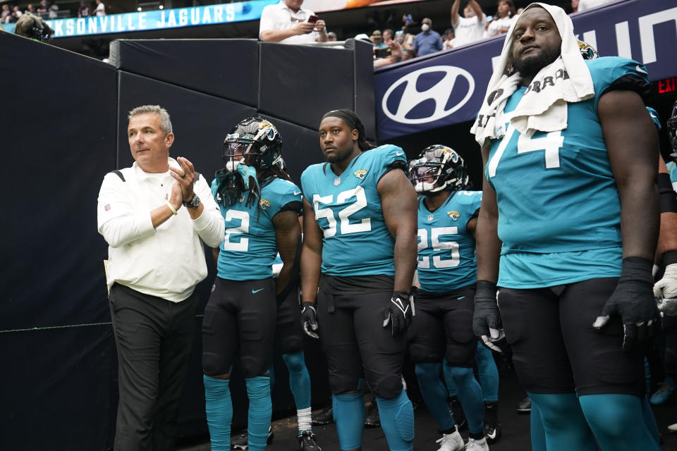 Jacksonville Jaguars coach Urban Meyer, left, prepares to lead his team onto the field before an NFL football game against the Houston Texans Sunday, Sept. 12, 2021, in Houston. (AP Photo/Sam Craft)