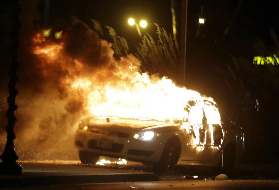 Autos y negocios ardieron en Ferguson tras el fallo que exoneró al policía que mató al joven Brown. (AP)