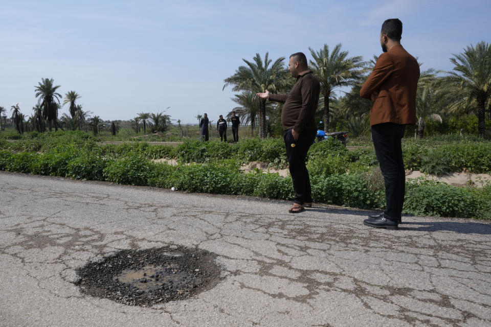 Relatives of people killed in a car by planted explosive visit the scene in Muqdadiyah, Iraq, Wednesday, March 22, 2023.It is not known who carried out the attack. Diyala province has seen a spike in killings, some connected to sectarian hatreds but others believed linked to rivalries among Shiite factions. (AP Photo/Hadi Mizban)