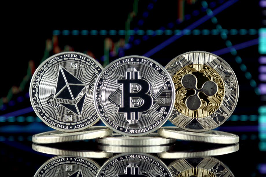Bitcoin-, Ripple- und Ethereum-Münze vor Chart