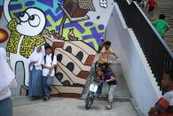 In this Monday, Feb. 13, 2017 photo, high-school students have their photo taken as children play at Kalijodo Park which is often claimed by the incumbent Jakarta Governor Basuki Tjahaja Purnama who turned the area from a red-light district into a modern skatepark as a legacy of his administration, in Jakarta, Indonesia. Residents of Indonesia's capital vote Wednesday in an election for governor that has become a high-stakes tussle between conservative and moderate forces in the world's most populous Muslim nation. Religion and race, rather than the slew of problems that face a car-clogged and sinking city, have dominated the campaign. (AP Photo/Dita Alangkara)