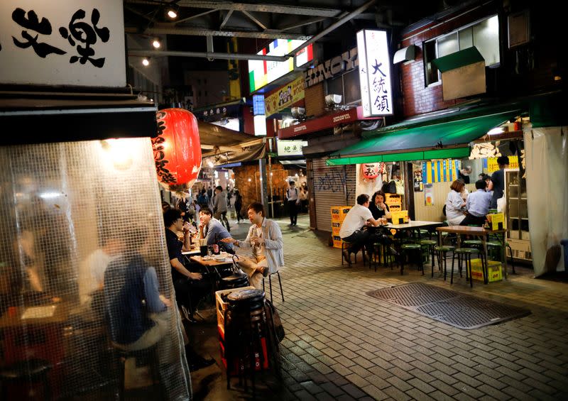 FILE PHOTO: People enjoy drinks and dinner at a Japanese izakaya pub, as the spread of the coronavirus disease (COVID-19) continues, in Tokyo