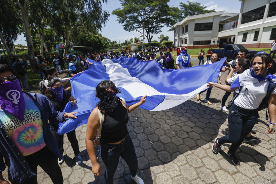 Students, some hiding their identify for fear of being identified and later attacked by security forces or government supporters, protest inside the Central American University (UCA) where security forces cannot legally enter to demand the release of all political prisoners in Managua, Nicaragua, Tuesday, June 18, 2019, the last day of a 90-day period for releasing such prisoners as part of negotiations between the government and opposition. Nicaragua's government said Tuesday that it has released all prisoners detained in relation to 2018 anti-government protests, though the opposition maintains that more than 80 people it considers political prisoners are still in custody. (AP Photo/Alfredo Zuniga)