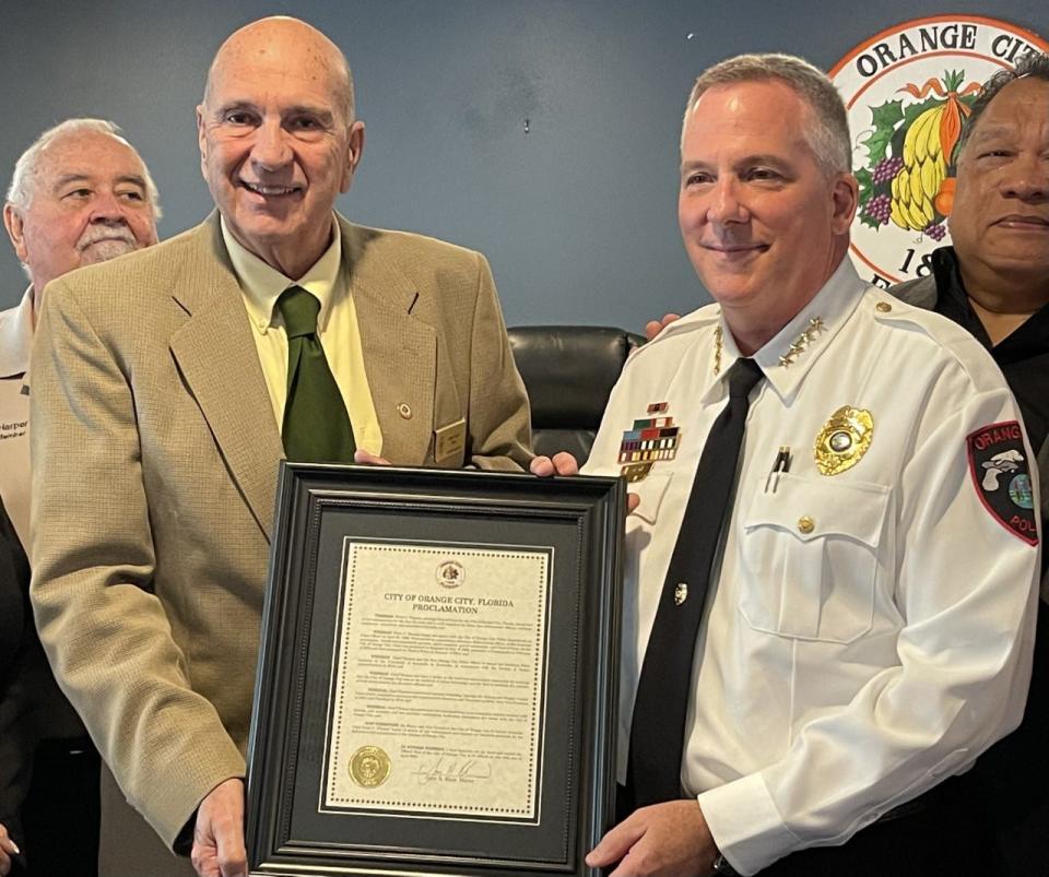 Orange City Mayor Gary Blair, left, presents Peter Thomas, who is retiring as police chief, with a proclamation on Tuesday. Thomas served 30 years with the Orange City Police Department, the city's longest tenured officer.