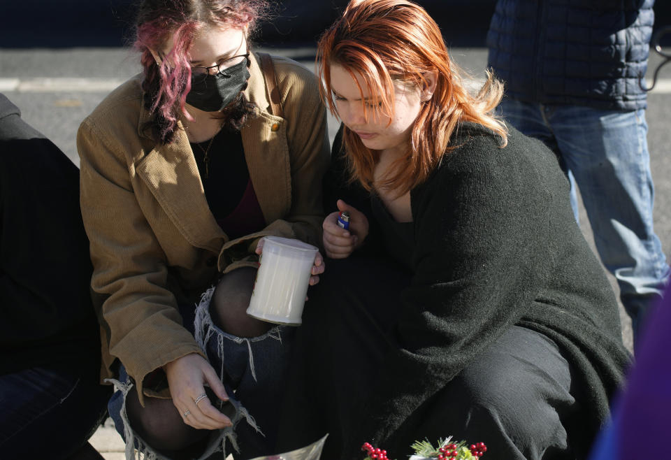 Reese Congleton, left, and Ashlyn May leave a votive candle at a makeshift display on a corner near the site of a mass shooting at a gay bar Monday, Nov. 21, 2022, in Colorado Springs, Colo. (AP Photo/David Zalubowski)