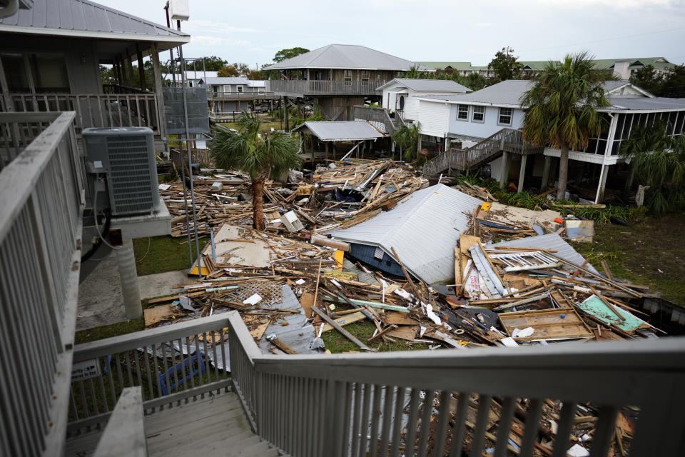 The remains of destroyed unstilted homes choke a canal surrounded by stilted buildings that remain standing, in Horseshoe Beach, Fla., Friday, Sept. 1, 2023, two days after the passage of Hurricane Idalia. (AP Photo/Rebecca Blackwell)