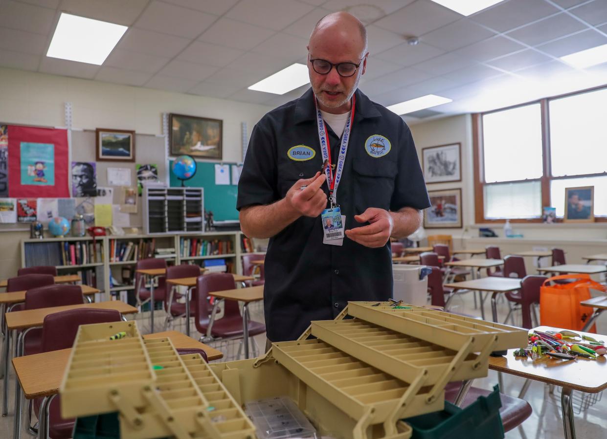 Green Bay East High School teacher Brian Fisk shows some of the fishing lures he has found. Fisk hunts for lost fishing lures and line in and near waterways in northeast Wisconsin. He refurbishes the lures and sells them, with 20% going to fund a fishing tournament for students each year.