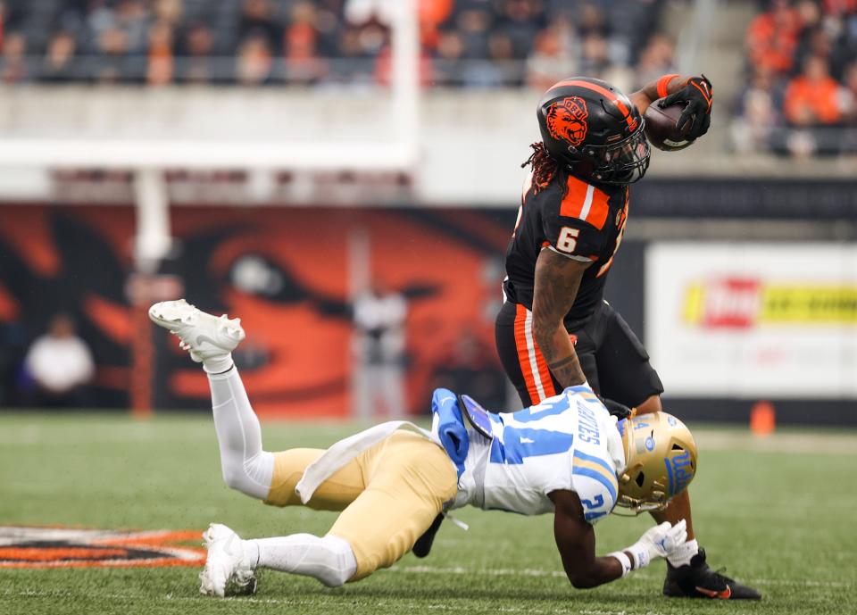 Oregon State Beavers running back Damien Martinez (6) holds off UCLA Bruins defensive back Jaylin Davies (24) during the first half of the game on Saturday, Oct. 14, 2023 at Reser Stadium in Corvallis, Ore.