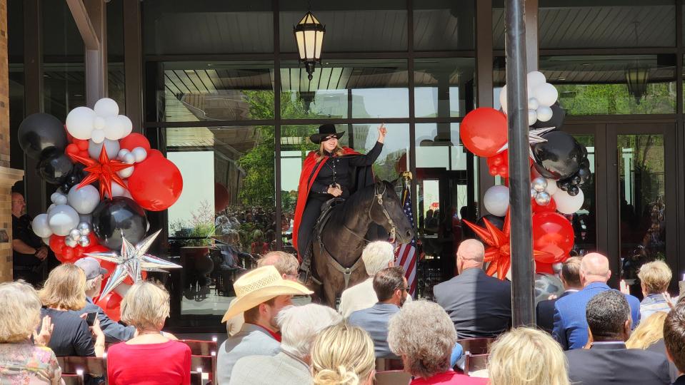 The Texas Tech Masked Rider gives the Tech "guns up" salute to the crowd Friday during the Texas Tech School of Veterinary Medicine ribbon-cutting ceremony.