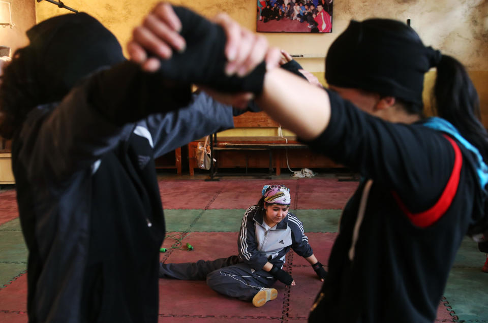 In this Wednesday, March, 5, 2014 photo, Afghan female boxers exercise during a practice session at the Kabul Stadium boxing club, Afghanistan. The women, who are 18 and older, don’t have much more than determination, and a trainer who runs them through their paces, watches as they spar, corrects their technique, tells them when to jab, how to protect themselves, when to power through with a left and then a right. (AP Photo/Massoud Hossaini)