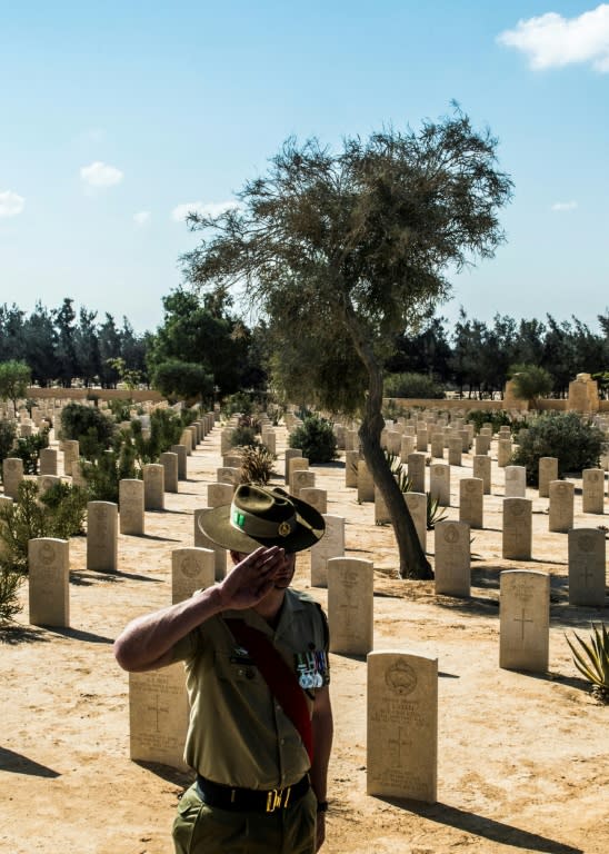 Australian Army's Chris Purdie salutes before a grave during a ceremony to mark 75 years since the pivotal WWII battle in the town of El Alamein, 100 kilometres (62 miles) west of Egypt's coastal city of Alexandria