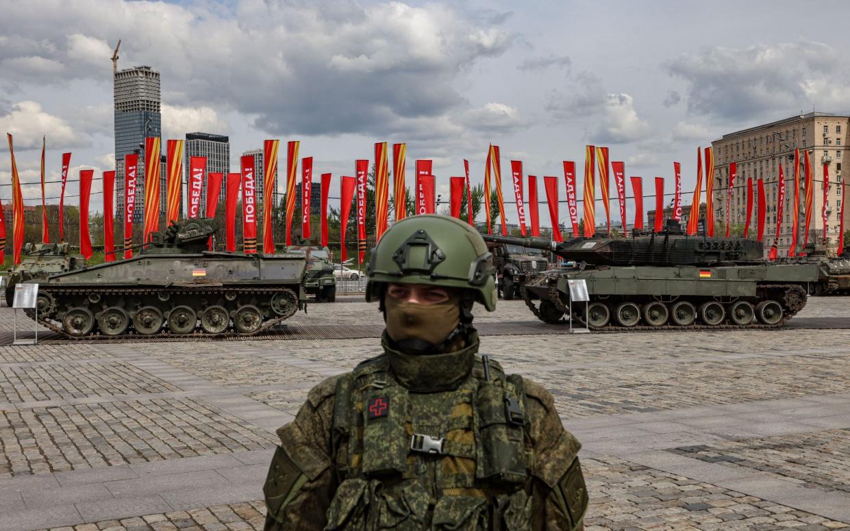 A Russian serviceman stands guard in front of the German Marder 1A3 infantry fighting vehicle and Leopard 2A6 main battle tank