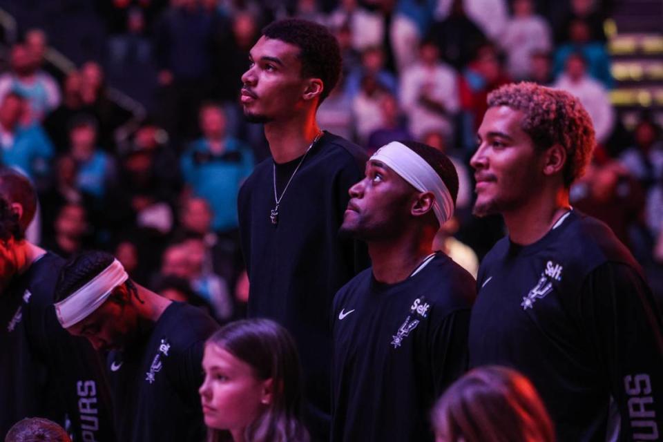 The Spurs’ Victor Wembanyama, center, stands with his teammates during a moment of silence before the game against the Hornets at Spectrum Center on Friday, January 19, 2024.