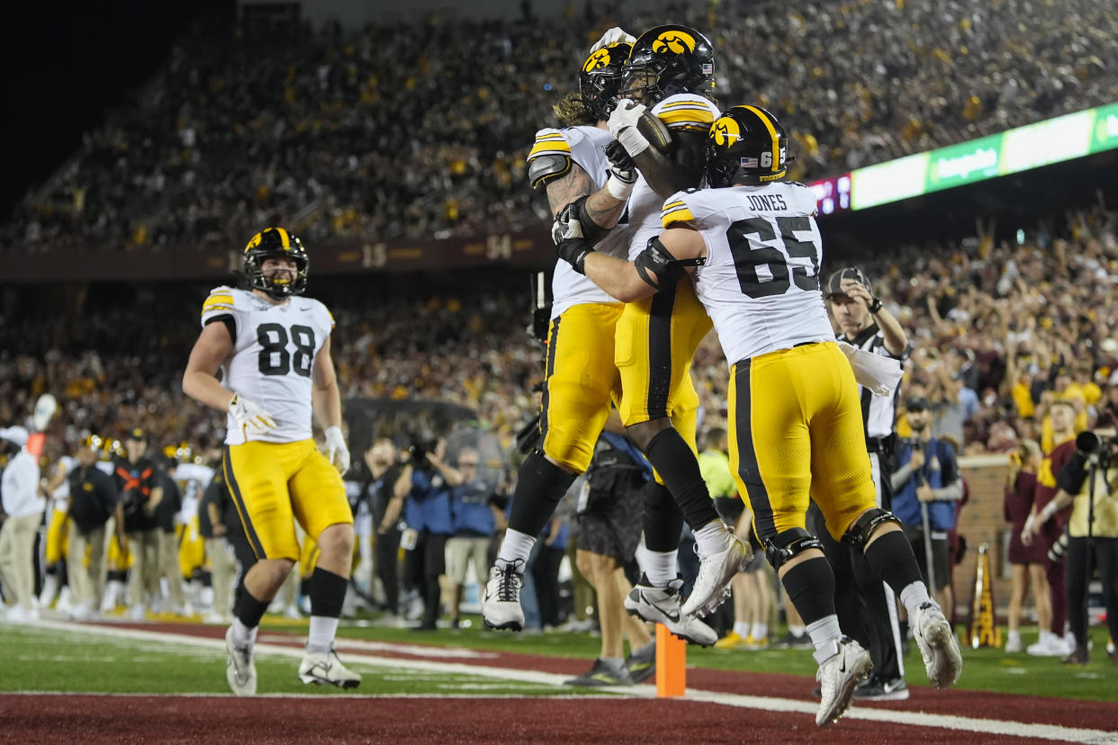 Iowa running back Kaleb Johnson, center, right, celebrates with teammates after scoring a 40-yard rushing touchdown during the second half of an NCAA college football game against Minnesota, Saturday, Sept. 21, 2024, in Minneapolis. (AP Photo/Abbie Parr)