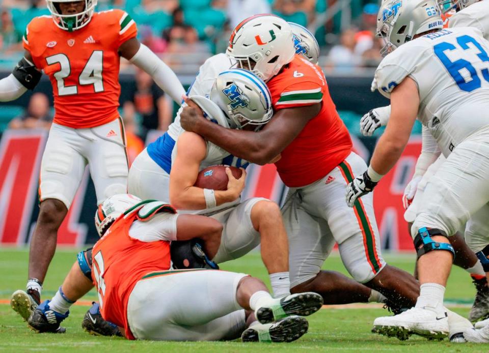 Miami Hurricanes defensive tackle Darrell Jackson tackles Middle Tennessee State quarterback Chase Cunningham at Hard Rock Stadium in Miami Gardens on Saturday, September 24, 2022.