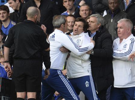 Chelsea's manager Jose Mourinho (2nd R) holds back assistant coach Rui Faria (C) after he was sent off by referee Mike Dean (L) during their English Premier League soccer match against Sunderland at Stamford Bridge in London, April 19, 2014. REUTERS/Philip Brown