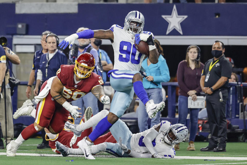 ARLINGTON, TX - DECEMBER 26: Dallas Cowboys defensive end Demarcus Lawrence (90) makes an interception and scores a touchdown during the game between the Dallas Cowboys and the Washington Football Team on December 26, 2021 at AT&T Stadium in Arlington, Texas. (Photo by Matthew Pearce/Icon Sportswire via Getty Images)