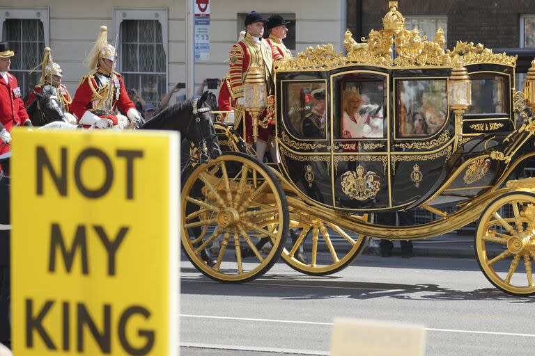 Los manifestantes antimonarquía se manifiestan mientras el rey Carlos III y la reina Camilla pasan en su carruaje hacia las Cámaras del Parlamento antes de la apertura estatal del Parlamento en la Cámara de los Lores, Londres, el miércoles 17 de julio de 2024.