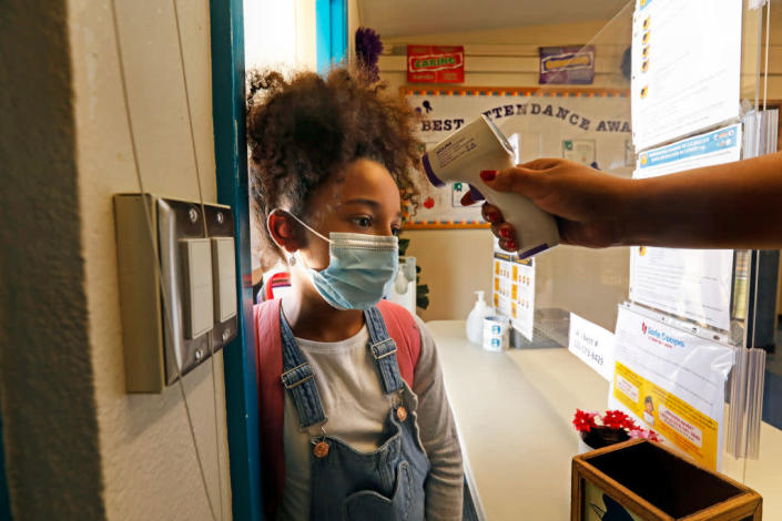 Zadie Williams, 8, gets her temperature checked before entering summer school in the fourth grade at Hooper Avenue School in Central Los Angeles on June 23, 2021. (Carolyn Cole / Getty Images)