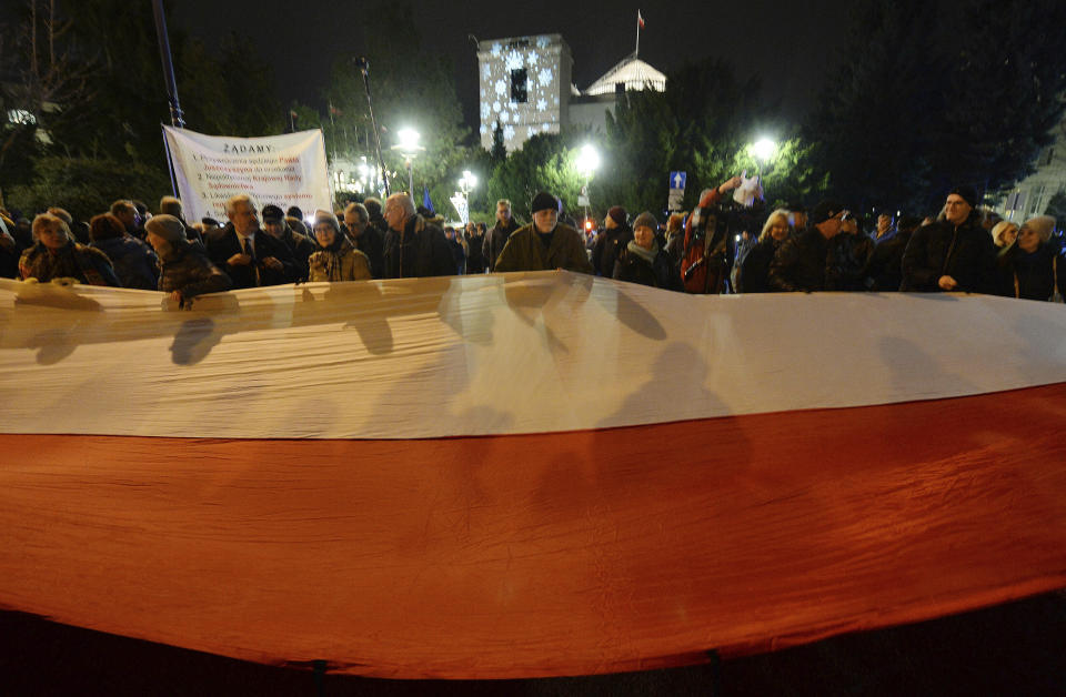 Demonstrators hold a rally to protest against changes to Poland's judiciary planned by the ruling Law and Justice party near the building of parliament in Warsaw, Poland, Wednesday, Dec. 18, 2019. (AP Photo/Czarek Sokolowski)