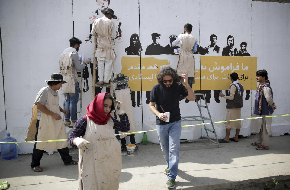 Artists paint a mural of journalists who have been killed during the year of 2018, in Kabul, Afghanistan, Tuesday, Sept. 25, 2018. It's the first in a series of murals planned by Amnesty International and the Artlords collective to highlight the work of Afghan activists, teachers, lawyers, students, trade unionists and others. (AP Photo/Massoud Hossaini)